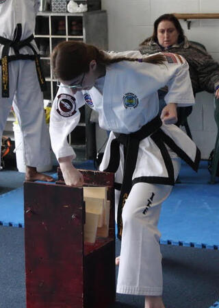 Breaking two boards with a downward punch at my third degree black belt test.